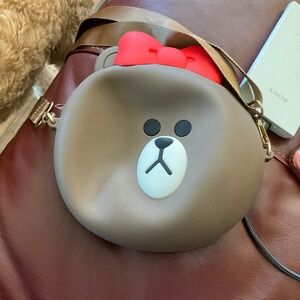 Cute bear purse for kids, brown with a red bow and brown strap.